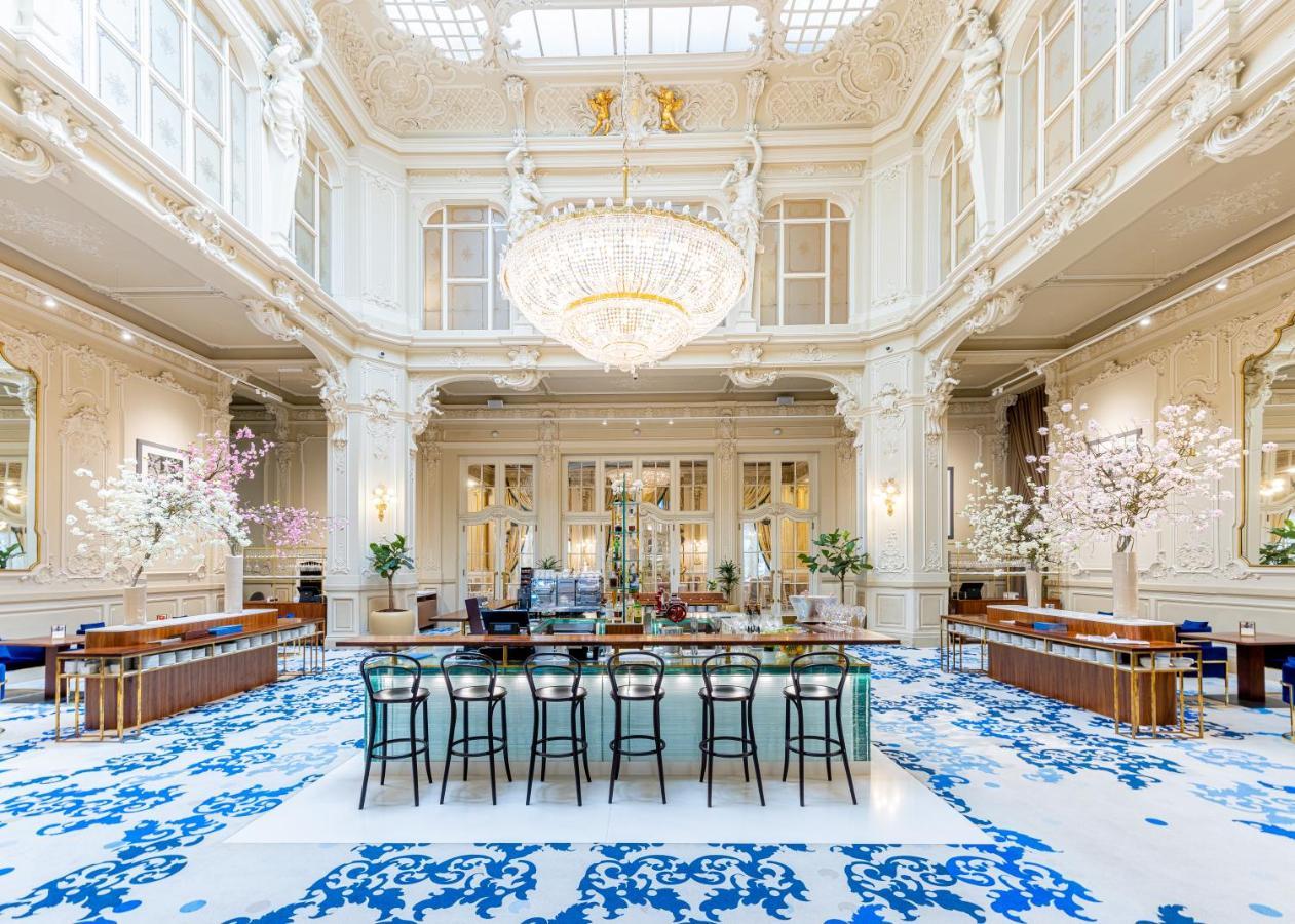 Grandhotel Pupp Karlovy Vary Luaran gambar The photo shows an elegant interior space, likely a hotel lobby or a high-end establishment. The room features high ceilings adorned with ornate moldings and a large chandelier that hangs prominently from the ceiling. The space is filled with natural