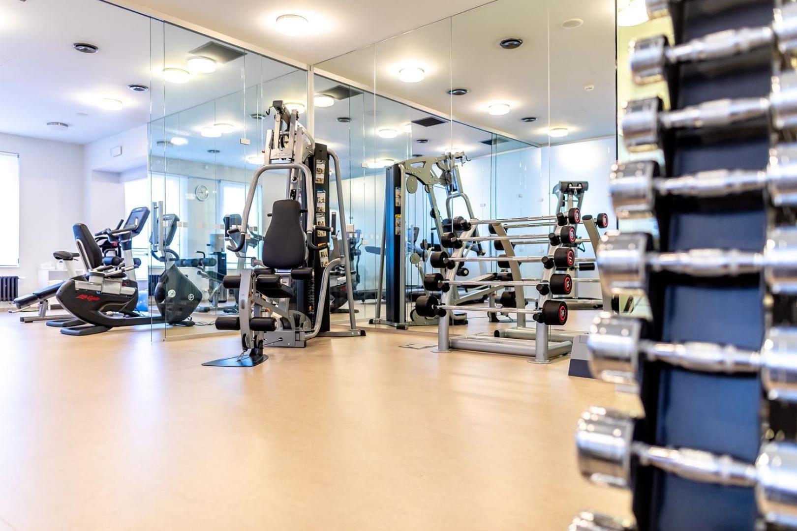 Grandhotel Pupp Karlovy Vary Luaran gambar The photo shows an interior view of a gym or fitness center. In the foreground, there is a rack of dumbbells arranged by weight, highlighting strength training equipment. In the background, various exercise machines are visible, including a stationar